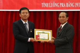 Tổng Lãnh sự Luang Prabang Trần Văn Tuấn thay mặt tập thể Tổng lãnh sự quán nhận huy chương hữu nghị của Chính phủ Lào từ ông Khamkhan Chanthavisuk, Ủy viên Trung ương Đảng, Bí thư, Tỉnh trưởng Luang Prabang. (Ảnh: Phạm Kiên/Vietnam+)