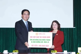 Chủ tịch Trung ương Hội Chữ thập Đỏ Việt Nam Nguyễn Thị Xuân Thu tiếp nhận số tiền 100.000 USD do Đại sứ Hồng Tiểu Dũng đại diện cho Chữ thập Đỏ Trung Quốc ủng hộ đồng bào miền Trung. (Ảnh: Quý Trung/TTXVN)