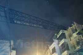 Cần cẩu dài hàng chục mét đổ sang nóc ngôi nhà trên phố Thụy Khuê. (Ảnh: Sơn Bách/Vietnam+)