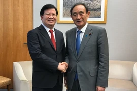 Phó Thủ tướng Trịnh Định Dũng gặp, hội đàm với Chánh văn phòng nội các Nhật Bản Yosihide Suga. (Ảnh: Thành Hữu/Vietnam+)