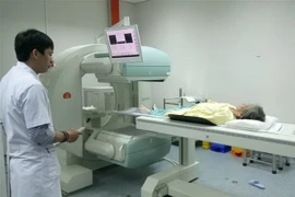 Bệnh nhân ung thư được đưa vào máy kiểm tra di căn ung thư xương. (Ảnh: TTXVN)