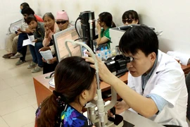 Bác sỹ khám và điều trị cho người đau mắt đỏ tại Bệnh viện Mắt Trung ương. (Ảnh: TTXVN/Vietnam+)