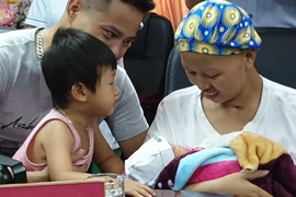 Gia đình chị Liên đón em bé xuất viện về nhà. (Ảnh: PV/Vietnam+)