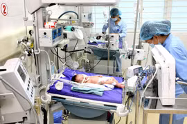 Y bác sỹ điều trị cho bệnh nhân nhi. (Ảnh: Dương Ngọc/TTXVN)