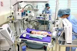 Y bác sỹ điều trị cho bệnh nhân nhi. (Ảnh: Dương Ngọc/TTXVN)
