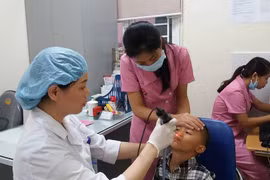 Bác sỹ khám cho trẻ có dị tật ở môi. (Ảnh: PV/Vietnam+)