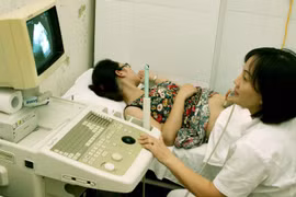 Nhân viên y tế kiểm tra sức khỏe sinh sản cho một phụ nữ. (Ảnh: TTXVN)