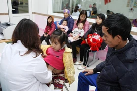 Bác sỹ khám cho bệnh nhân nhi. (Ảnh: Lâm Khánh/TTXVN)