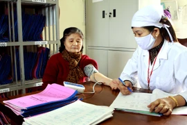 Nhân viên y tế kiểm tra sức khỏe cho bệnh nhân tăng huyết áp. (Ảnh: TTXVN)