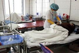 Nhân viên y tế chăm sóc sức khỏe cho bệnh nhân. (Ảnh: Dương Ngọc/TTXVN)