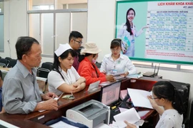 Bệnh nhân làm thủ tục khám chữa bệnh. (Ảnh: Phương Vy/TTXVN)