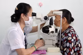 Nhân viên y tế khám mắt cho người dân. (Ảnh: TTXVN/Vietnam+)