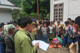 Phát hàng hỗ trợ cho người dân bị ảnh hưởng bởi lũ tại xã Nặm Păm, Sơn La. (Ảnh: Hữu Quyết/TTXVN)