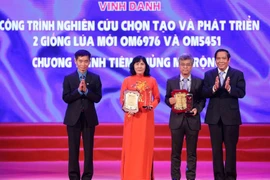 Giáo sư Đặng Đức Anh - Viện trưởng Viện Vệ sinh dịch tễ Trung ương (bên phải) nhận biểu trương vinh danh cho công trình. (Ảnh: Dương Giang/TTXVN)