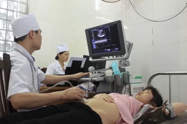 Bác sỹ đang thăm khám cho một bệnh nhân bảo hiểm y tế. (Ảnh: TTXVN)