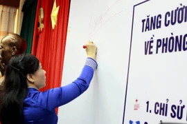 Bộ trưởng Bộ Y tế Nguyễn Thị Kim Tiến ký cam kết sử dụng kháng sinh có trách nhiệm. (Ảnh: Dương Ngọc/TTXVN)