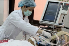 Nhân viên y tế chăm sóc người bệnh. (Ảnh: TTXVN/Vietnam+)