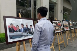 Người dân xem ảnh trưng bày về sự kiện APEC. (Ảnh: PV/Vietnam+)