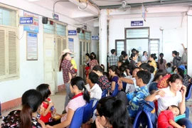 Người dân ngồi chờ khám bệnh trong những ngày nắng nóng. (Ảnh: TTXVN/Vietnam+)