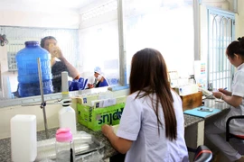 Nhân viên y tế giám sát điều trị Methadone cho bệnh nhân nhiễm HIV/AIDS. (Ảnh: TTXVN/Vietnam+)