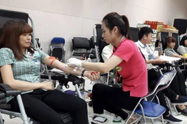 Nhân viên của Công ty tham gia hiến máu tại chương trình. (Ảnh: PV/Vietnam+)