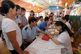 Lấy mẫu máu xét nghiệm của các tình nguyện viên trước khi hiến máu. (Ảnh: TTXVN)