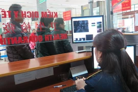 Giám sát chặt chẽ khách xuất nhập cảnh tại cửa khẩu quốc tế Lào Cai bằng máy đo thân nhiệt. (Ảnh: Lục Hương Thu/TTXVN)