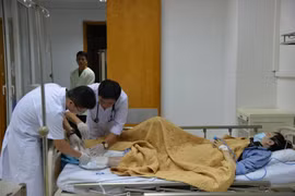 Các bác sỹ kiểm tra vết thương ở chân cho bệnh nhân. (Ảnh: PV/Vietnam+)