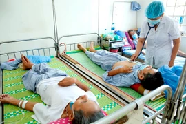 Bác sỹ thăm khám, điều trị cho bệnh nhân. (Ảnh: TTXVN)