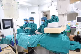 Các bác sỹ thực hiện can thiệp nội mạch cho bệnh nhân. (Ảnh: PV/Vietnam+)