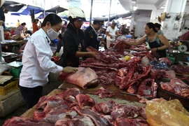 Nhân viên Chi cục thú y kiểm tra cơ sở kinh doanh thịt gia súc, gia cầm. (Ảnh: TTXVN/Vietnam+)