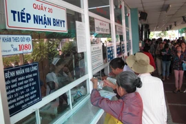 Nhân viên y tế giải quyết các thủ tục khám chữa bệnh cho người có thẻ bảo hiểm y tế. (Ảnh: TTXVN/Vietnam+)