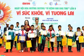 Đại diện Quỹ Ngày mai tươi sáng trao quà cho bệnh nhi ung thư. (Ảnh: Dương Ngọc/TTXVN)