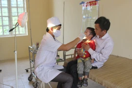 Cán bộ y tế tuyến xã khám bệnh cho trẻ nhỏ. (Ảnh: Quang Duy/TTXVN)