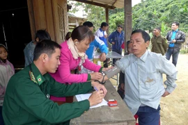 Bác sỹ quân y đồn biên phòng Đắc Pring khám chữa bệnh cho người dân tại cụm bản Pêtapoóc, Quảng Nam. (Ảnh: TTXVN/Vietnam+)