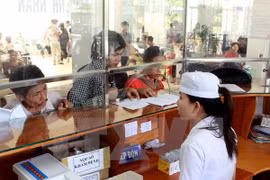 Người dân làm thủ tục khám chữa bệnh. (Ảnh: TTXVN)