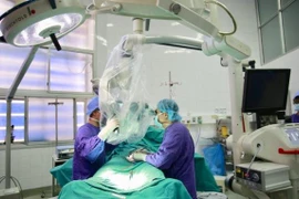 Các bác sỹ thực hiện ca phẫu thuật cho bệnh nhân. (Ảnh: PV/Vietnam+)