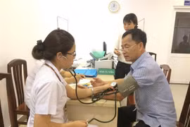 Đo huyết áp kiểm tra sức khoẻ cho người bệnh. (Ảnh: TTXVN/Vietnam+)