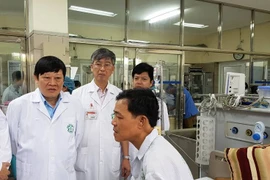 Thứ trưởng Bộ Y tế tới thăm bệnh nhân vừa được chuyển về điều trị tại Bệnh viện Bạch Mai. (Ảnh: PV/Vietnam+)