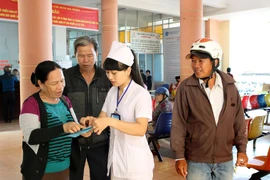 Nhân viên y tế hướng dẫn người dân khám chữa bệnh. (Ảnh: TTXVN/Vietnam+)