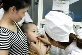 Nhân viên y tế cho trẻ uống Vitamin A. (Ảnh: Dương Ngọc/TTXVN)