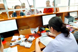 Nhân viên y tế hướng dân người bệnh làm thủ tục khám chữa bệnh. (Ảnh: Dương Ngọc/TTXVN)