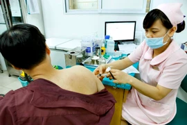 Tiêm phòng cho người dân tại Trung tâm tư vấn dịch vụ vắcxin tiêm chủng. (Ảnh: TTXVN)
