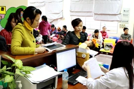Làm thủ tục khám bệnh tại Bệnh viện Nhi Trung ương. (Ảnh: TTXVN/Vietnam+)