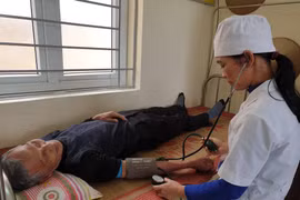 Nhân viên y tế khám bệnh cho người dân tạ Trạm y tế xã Kim Chính, tỉnh Ninh Bình. (Ảnh: T.G/Vietnam+)