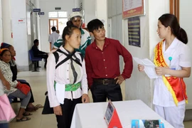 Nhân viên y tế hướng dẫn người dân làm thủ tục khám chữa bệnh. (Ảnh: TTXVN/Vietnam+)