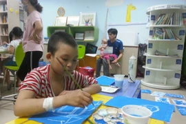 Chảo Mùi Mán đang chăm chú hoàn thành bức tranh vẽ nhà của mình. (Ảnh: Thu Hà-Hoài Thu)