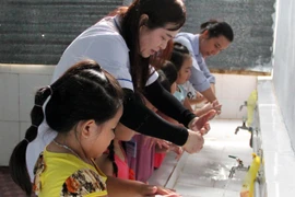 Hướng dẫn học sinh rửa tay bằng xà phòng phòng chống nhiều dịch bệnh. (Ảnh: TTXVN)