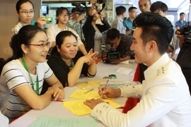 Ca sỹ Nguyễn Phi Hùng (phải) tham gia tư vấn để đăng ký hiến tạng trong một sự kiện Chung tay vì sự sống. (Ảnh: Phương Vy/TTXVN)