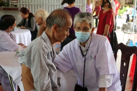 Bác sỹ khám bệnh cho người dân. (Ảnh: Như Bình/TTXVN)